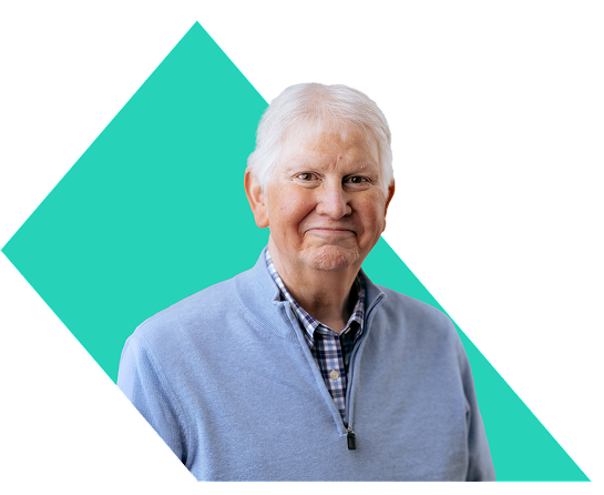 Bryan, a PYLARIFY patient, smiling in a collared button-up shirt and sweater